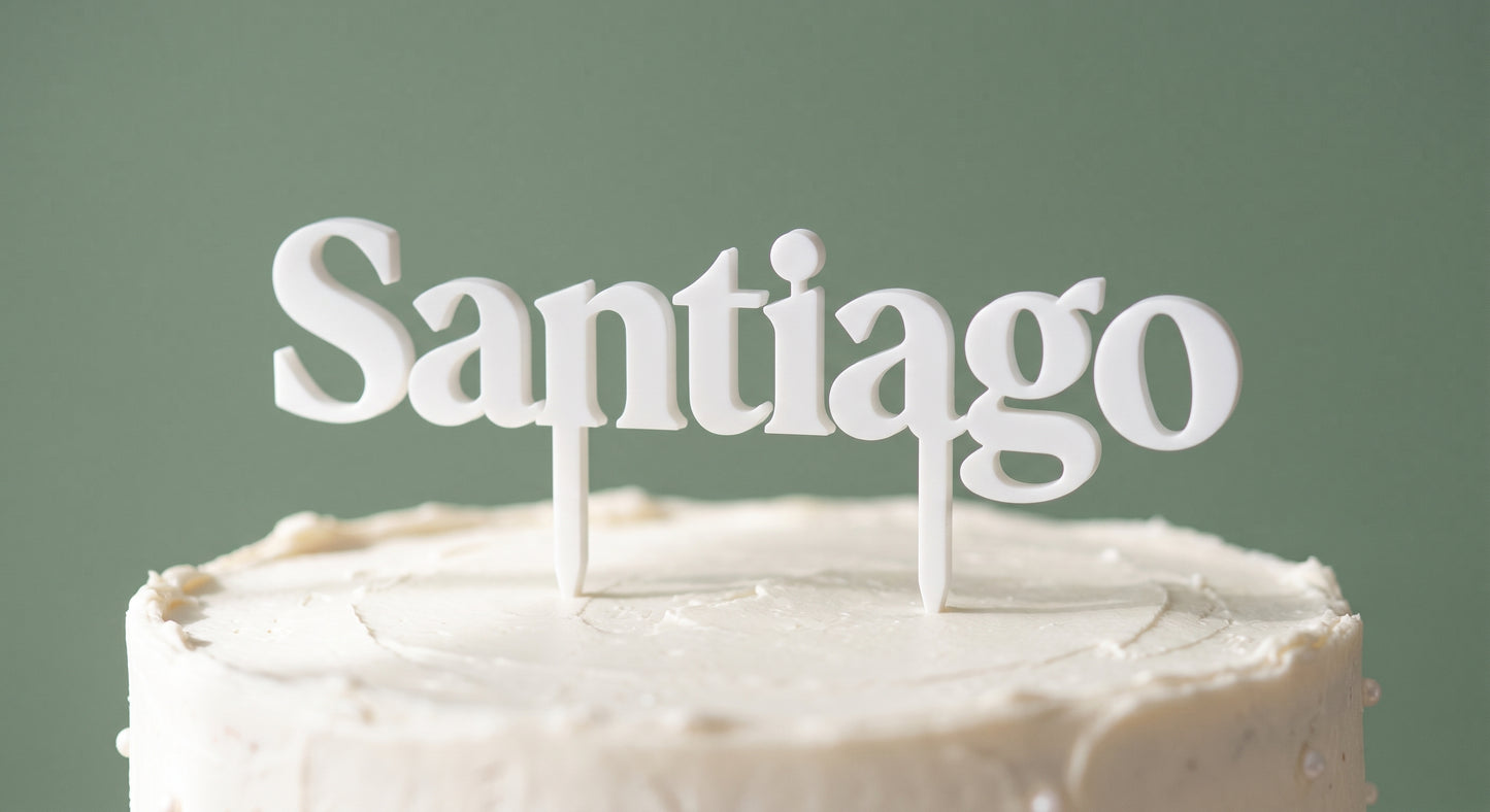 Santiago white cake topper standing on a frosted cake