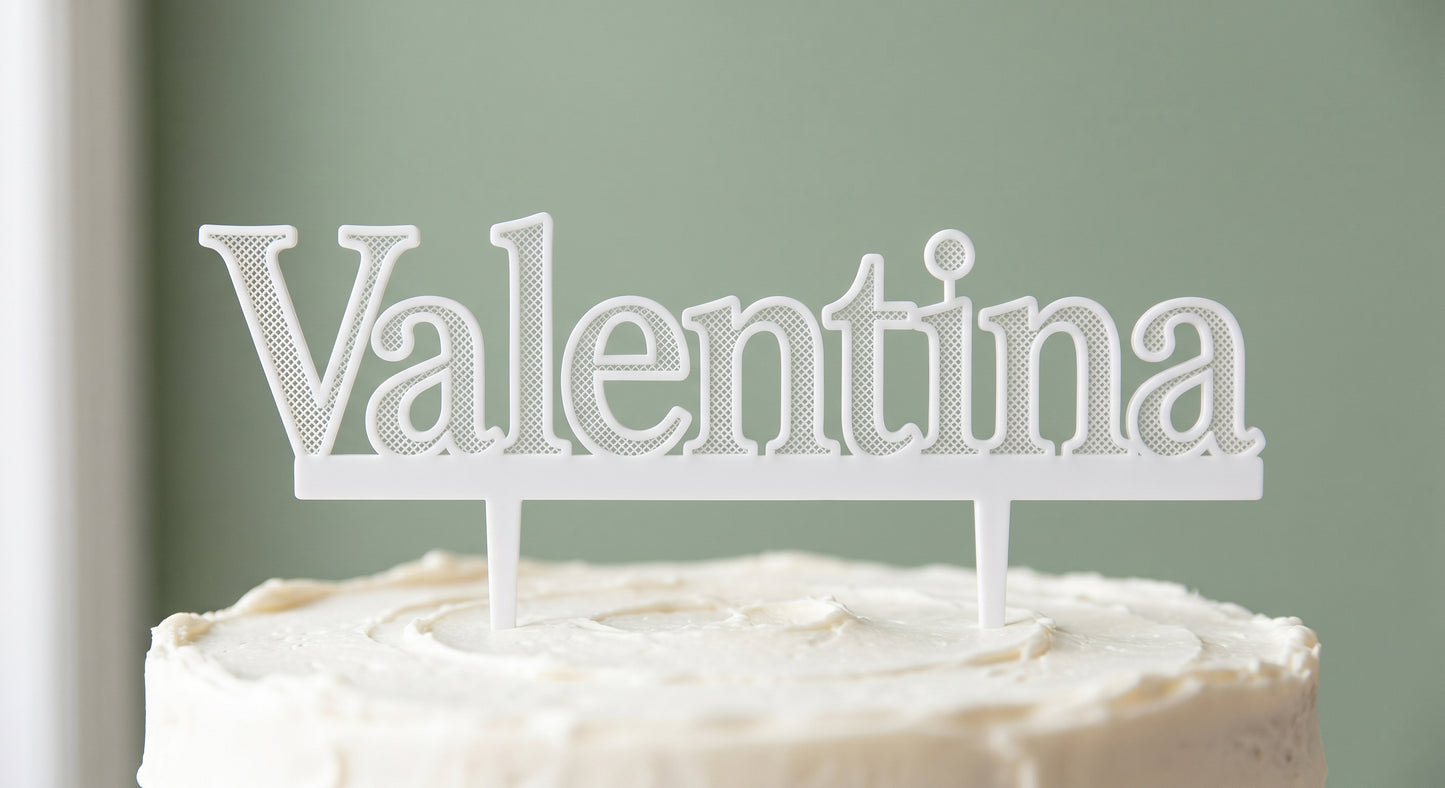 Valentina white cake topper standing on a frosted cake