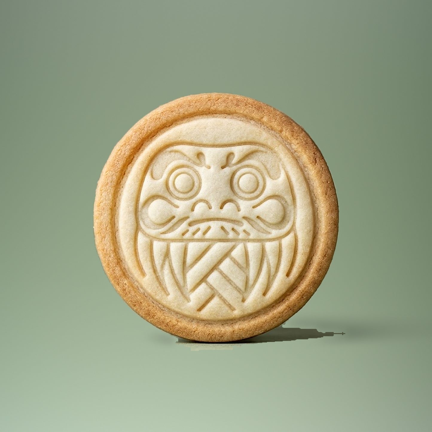 Daruma cookie stamp impression on a shortbread cookie, detailed design