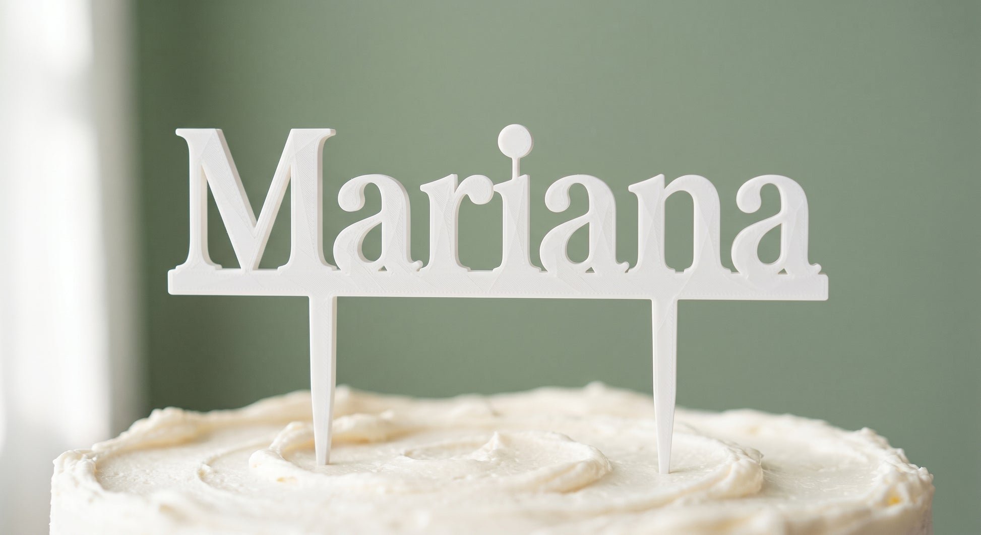 Mariana white cake topper standing on a frosted cake