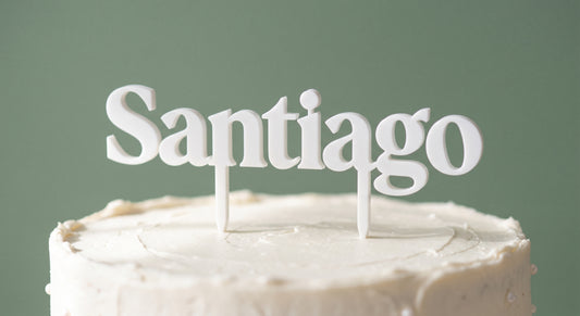Santiago white cake topper standing on a frosted cake